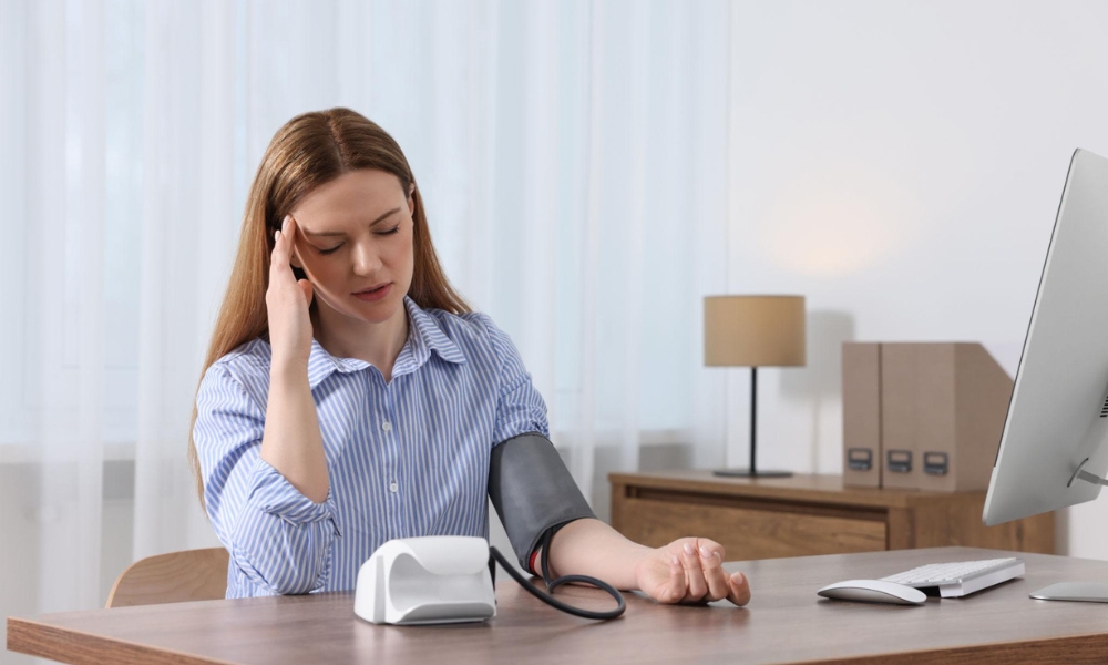 Patient checking high blood pressure using digital blood pressure monitor at home